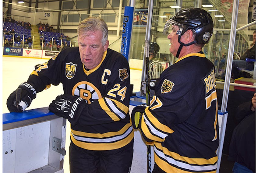 With Ray Bourque (right) ready to get on the ice, 66-year-old Terry O’Reilly seeks a respite after a long, gruelling shift.