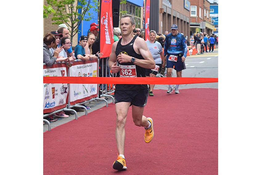 Dave MacLennan crosses the finish line at the 2017 Johnny Miles Marathon.