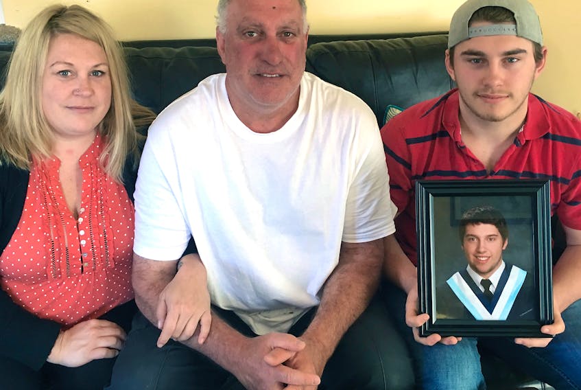 Kade Mason holds a picture of his older brother Kale. Also shown are Kale’s parents, Debbie and Kent Mason.