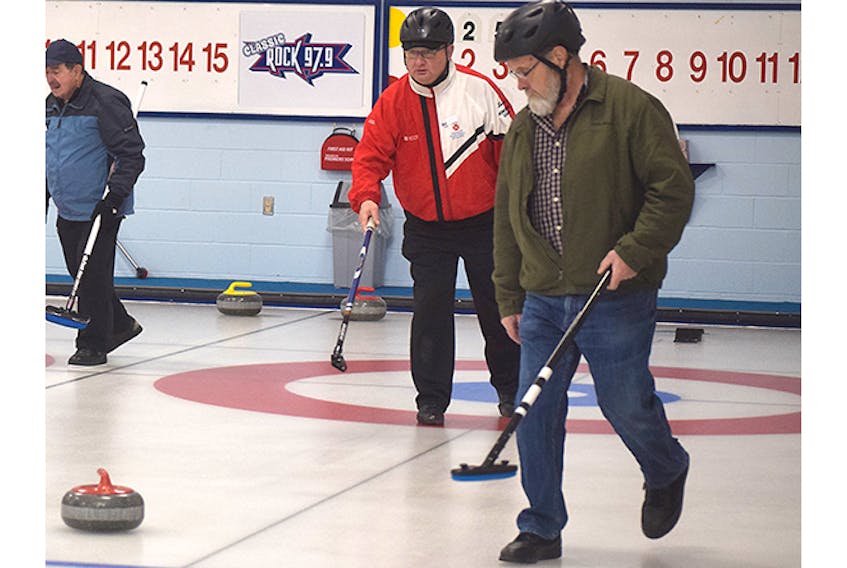 Skip Lorne Smith fires off a stone as second Allison Munroe keeps an eye on it during final-end play on Tuesday at Bluenose Curling Club.