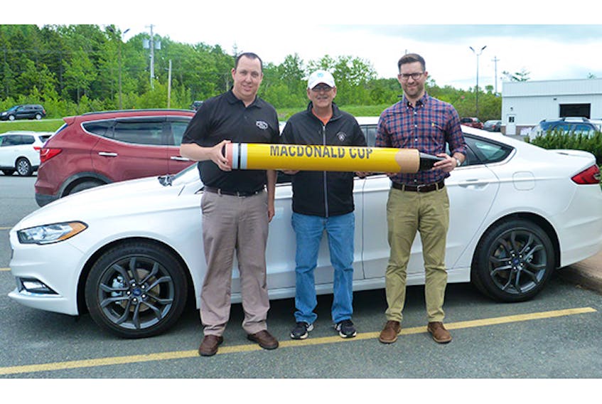 Manager Scott Fanning and Highland Ford general manager Matt Barker present the keys to a 2018 Ford Fusion to MacDonald Cup Fore Palliative Care host Mike MacNaughton.