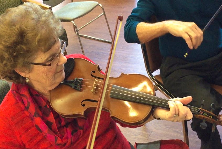 Marlene MacDonald, wife of composer Raymond MacDonald, plays the fiddle during a Celtic Fiddlers’ practice.