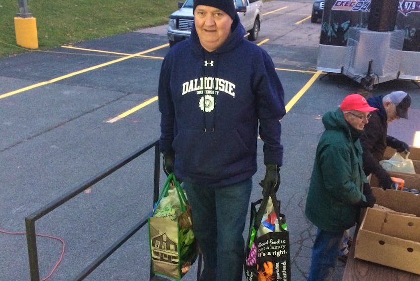Lauchie MacIsaac carries two bags of donations into a truck trailer, during the final hour of the Pictou County Food Drive. An unprecedented number of food and monetary donations were amassed at this year’s food drive.
