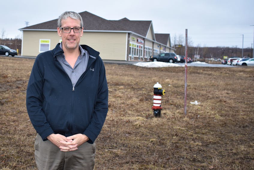 Stellarton Mayor Danny MacGillivray, on one of the lots to be sold to Endurance Equities Corp., with some of the other businesses in the Albion Business Park in the background.
