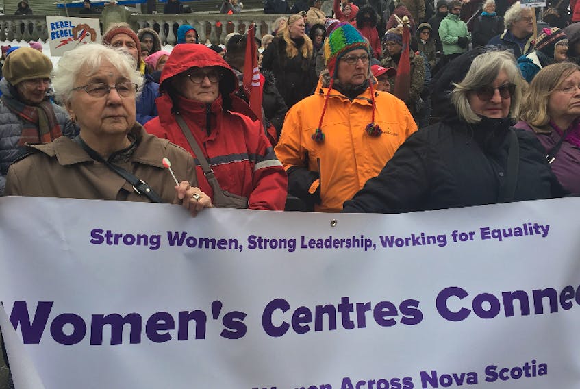 Shelley Curtis-Thompson (front right in black coat) holds aloft a Women’s Centres Connect banner with Gail Clarke (front left) from Pictou County at the 2018 March on Canada in downtown Halifax on Saturday.