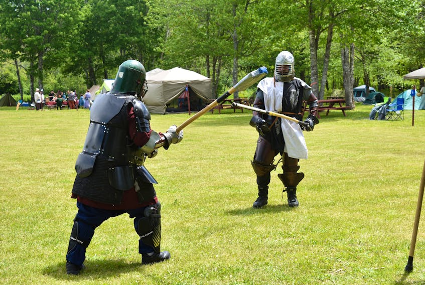 Two combatants in heavy armour prepare to engage in combat with polearms constructed of rattan in an event held by the Society for Creative Anachronism at LORDA.
