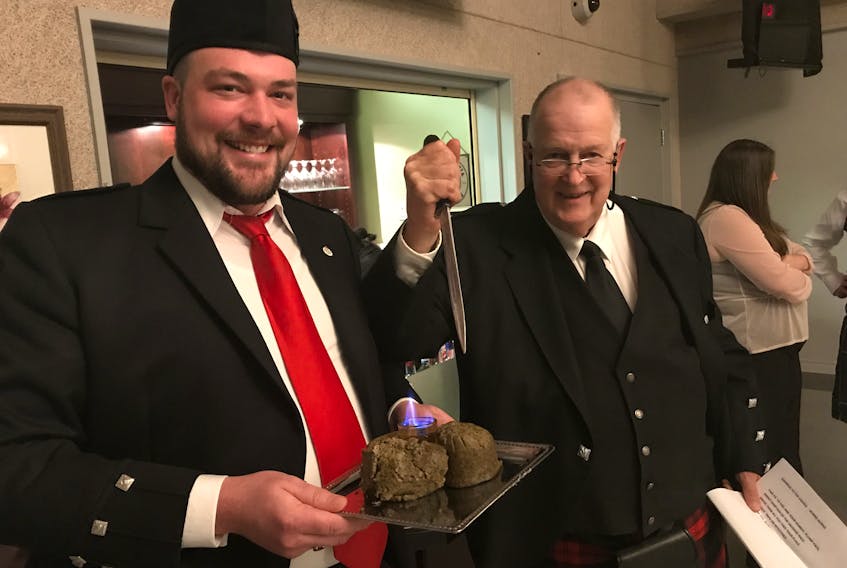 Jeff Davis (L) and James McLachlan posing with the haggis at Burns Night on Saturday in New Glasgow. The haggis dish was ceremoniously marched to the dinner tables by a bagpipe escort.