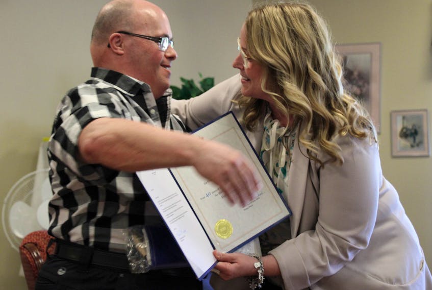 Pictou West MLA Karla MacFarlane gives Johnny MacLeod, a retiree of the Shiretown Nursing Home, a hug after presenting him with a certificate from the Nova Scotia Legislature in honour of his 40 years working at the home for special care. MacLeod said he now plans to spend his days helping his sister and aunt, but he will still continue to visit this former co-workers and residents at the home.  Sueann Musick/The News