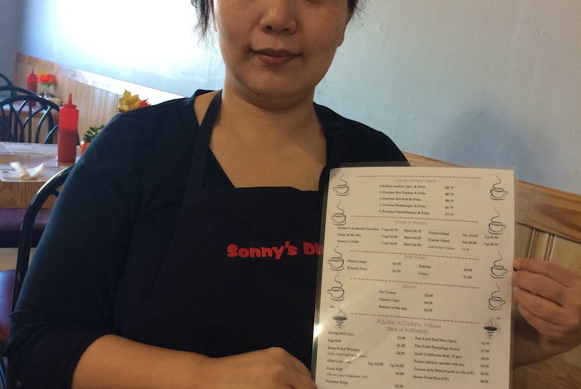 Alice Shang holds the menu of her new Trenton restaurant, Sonny’s Diner, featuring Canadian and Asian meals.