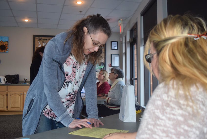 Volunteer Angie Degaust looks on as Dana Francis of Pictou Landing registers her daughter as a cancer survivor during an information session put on by Relay for Life organizers this week.