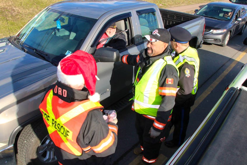 Operation Christmas kicked off Friday with a checkpoint on Westville Road, New Glasgow, involving many different emergency services. From the left, Dave White, John Desmond of the New Glasgow Fire Department and Walter Smith with the New Glasgow Regional Police Department hand out red ribbons from Pictou County MADD and information on the dangers of driving while impaired by drugs or alcohol.