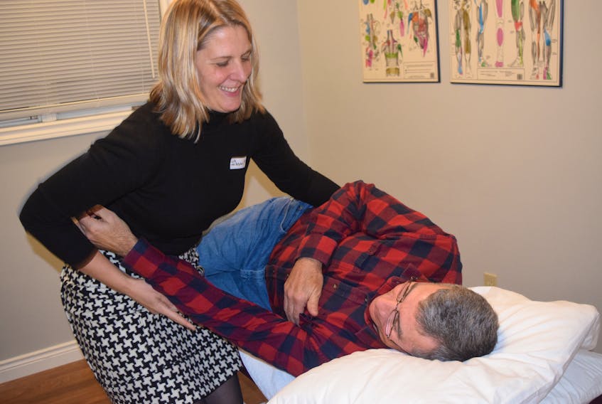 Liz van Zutphen, New Glasgow’s newest chiropractor, demonstrates her proficiency at aligning muscles and bones to relieve pain and injury on Dan Collier, one of the many guests at the official opening of Balance Physiotherapy.