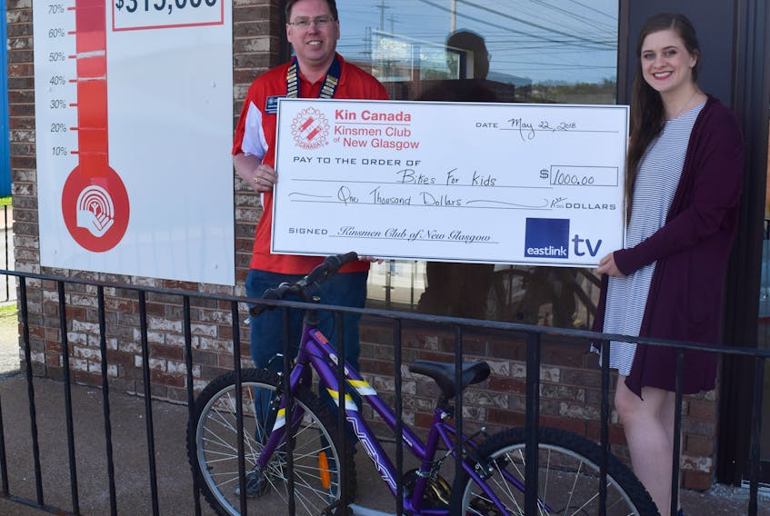 New Glasgow Kinsmen Club president Brian MacIntosh presents April MacDonald, United Way Bikes for Kids co-ordinator, with a cheque for $1,000 to help the program.