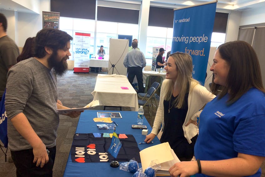 Josh Grant, consults with Leah LeBlanc, upper right, and Erin Wadden with Randstad, on Wednesday afternoon. Grant was one of many people checking out employer tables at the Pictou County 2018 Job Fair.