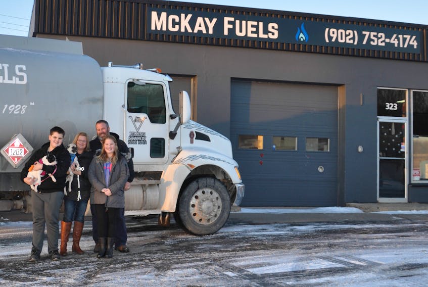McKay Fuels has found a new home on East River Road. Owner Kevin McKay said they were looking for a more visible location. From left are Joel, Vicki, Kevin and Casey McKay. Also pictured are their dogs Roxy and Frank.
