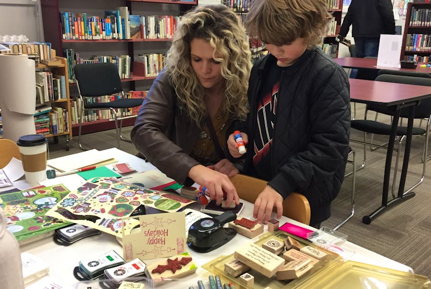 Camilla MacDonald and her son Cal, working on a Christmas card for Cal’s father, at the Stellarton Library.
