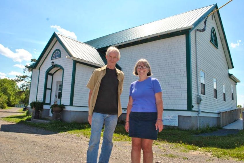 Dave Hillier and Debbie Ratcliffe stand outside the Merigomish Schoolhouse Community Centre.