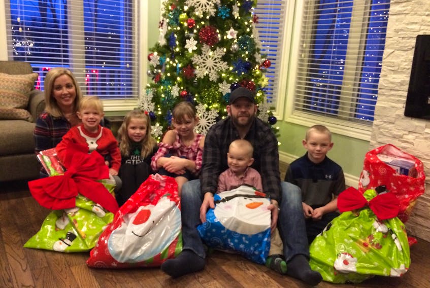 Graham’s Glass and Exteriors joined together with the Forward family of Abercrombie to make Christmas special for another Pictou County family.  From the left: Rachel Forward, Keegan Forward, Addie Rae Forward, Tori Hayden, Graham Hayden, Kaisaac Hayden and Tanner Hayden sit with some of the gifts purchased through their joint effort.