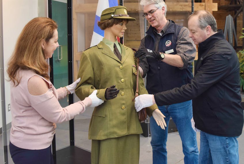 Museum of Industry employees Denise Taylor and Andrew Phillips with help from David Avery set up a manikin wearing a uniform that would have been worn by a captain in the Canadian Women’s Army Corps during the Second World War.