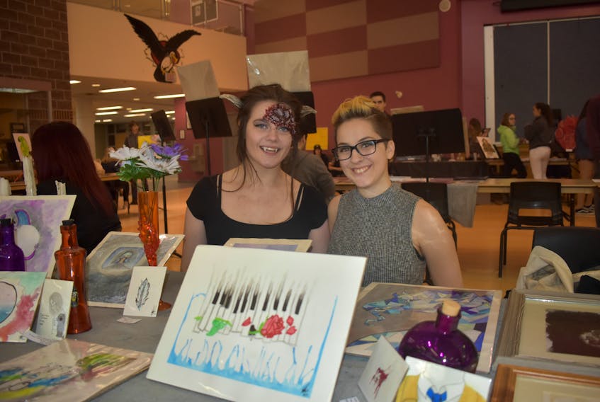 Kalie Stevens-Rochon, right, and the model for her makeup skills, Karley Dixon, at Northumberland Regional High School with some of Stevens-Rochon's watercolour paintings and sketches in the in the foreground.