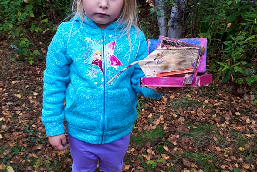 Ava Anderson holds a bird feeder that was demolished by vandals last week. The feeders had been built by pre-schoolers at Creative Beginnings in Stellarton.