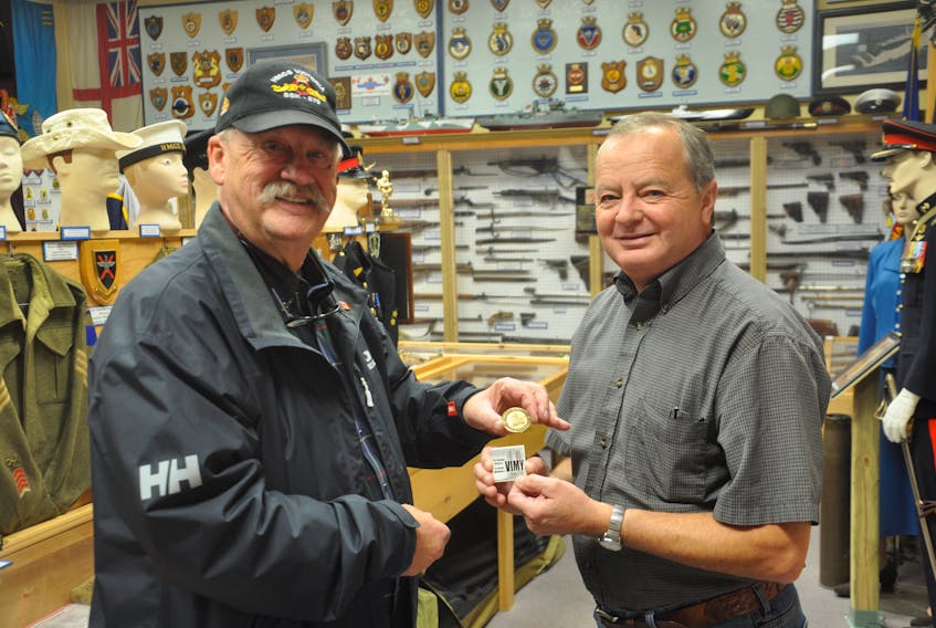 Rod McLeod, a designer and manufacturer of coins for the Canadian military, poses with David Avery, president of the Pictou County Military Heritage Museum on Sunday. McLeod donated a collection of coins to the museum.