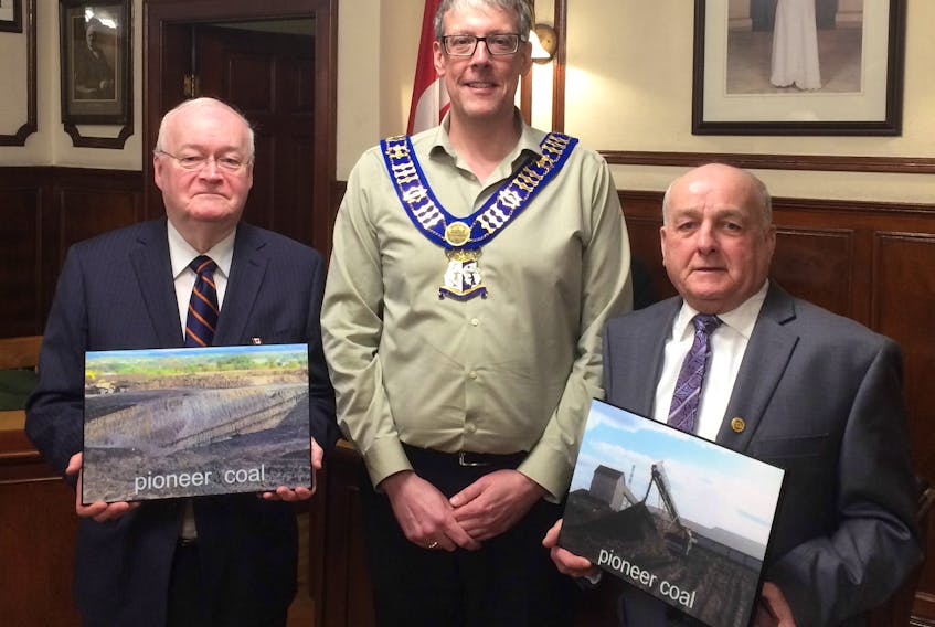 Stellarton Mayor Danny MacGillivray accepts two plaque boards from Philip MacKenzie and Clyde Macdonald. The historical plaques depict photos of Pioneer Coal, and are part of a larger project in which MacKenzie and Macdonald will donate plaques to businesses in Stellarton that depict its heritage.