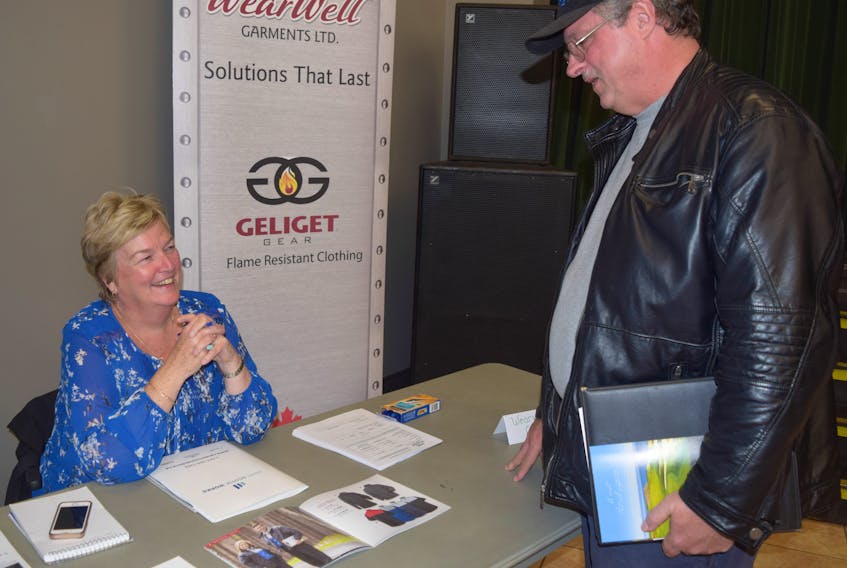 Wear Well Garments HR and payroll manager Mary Connors speaks with Terry Beaver during a job fair held at Glasgow Square Friday.