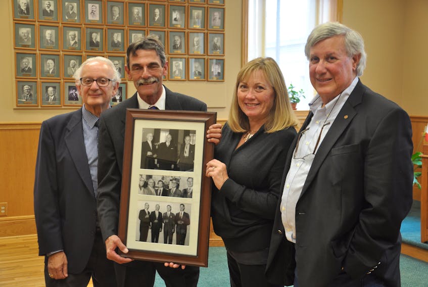 Rick Goodman, George Goodman, New Glasgow Mayor Nancy Dicks and Paul Goodman, with the photos going up in the New Glasgow Town Hall to honour the historical contributions to the local business community of the Goodman family.