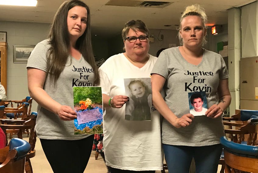Kevin Martin’s mother Bonnie Thomas (centre) and her surviving children Samantha (L) and Danielle hold up pictures of their loved one at the Stellarton Legion on May 19.