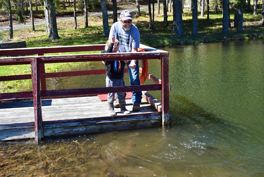 Brock Aikens and his grandfather, Donnie feed the fish at LORDA. They were among a number of guests enjoying the sunny weather on Friday afternoon at the park in Lansdowne.