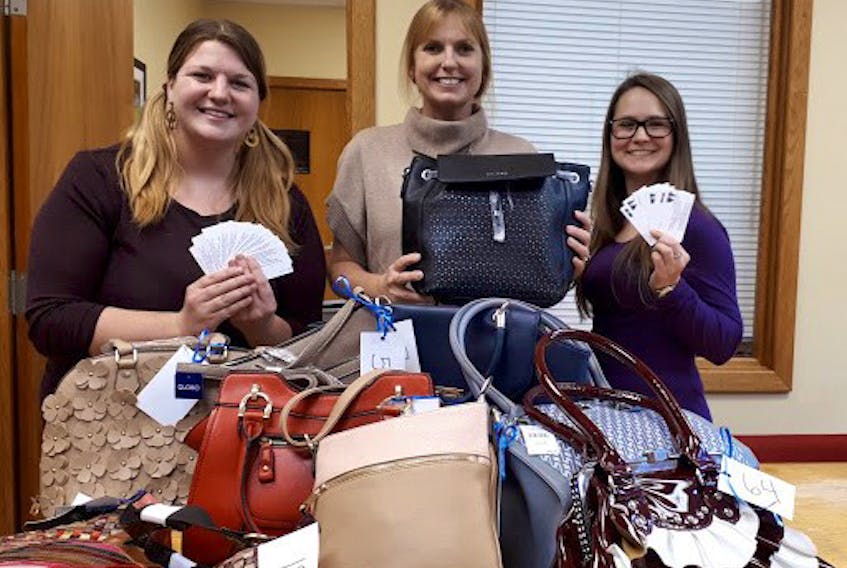 Preparing to sell tickets and display handbags for the silent auction from left to right are: Project Coordinator, Mary Frances Galvin, Mentoring Coordinator, Roxanne MacLean Swinamer and University of Moncton social work student, Sheila Booth.