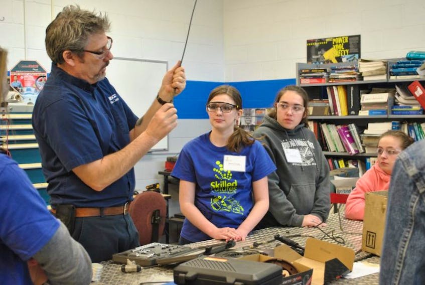 Automotive instructor Damien Hall shows students a fluid line as part of a Skilled Futures in Trades and Technology workshop organized by Skills Canada – Nova Scotia, a not-for-profit organization that provides opportunities for youth to explore skilled trades and technologies, discover their passions and strive for excellence.