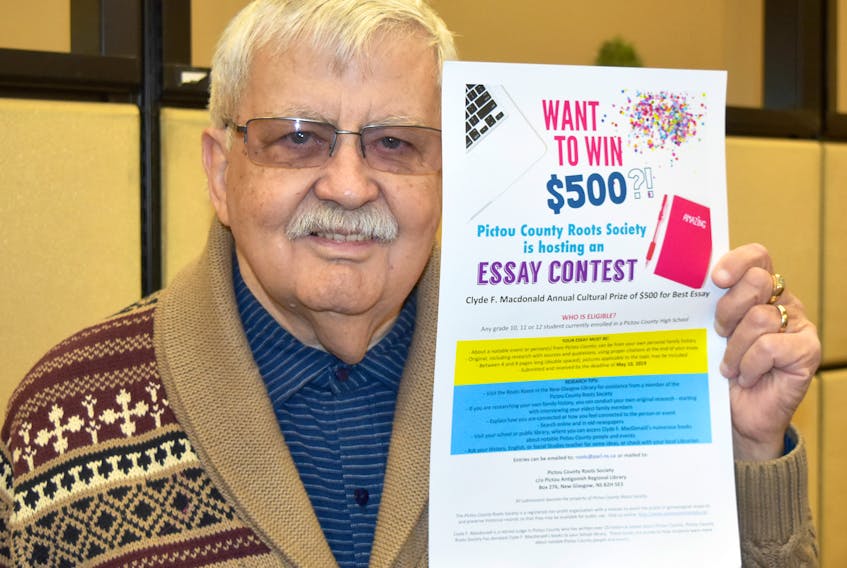Lloyd Tattrie of the Pictou County Roots Society holds a poster for an essay contest the group is putting on for students in grades 10, 11 and 12.