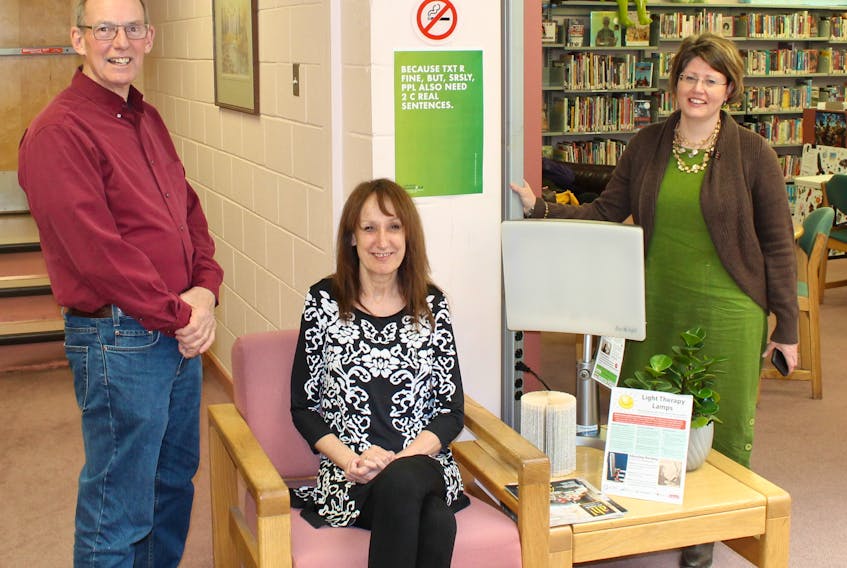 Trecia Schell, right, community services and branch librarian for the Pictou-Antigonish Regional Library, demonstrates the new light therapy lamps to community health board members Pat MacDonnell and Julie Martin.
