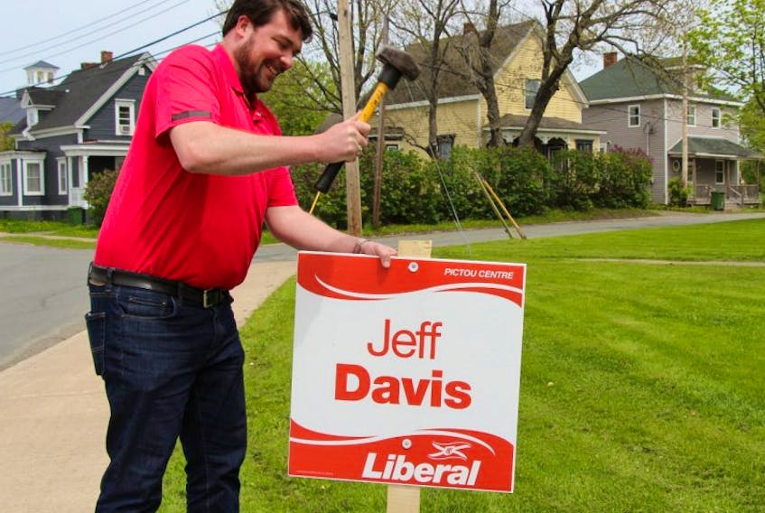 Pictou Centre Liberal candidate Jeff Davis places a sign in New Glasgow.
