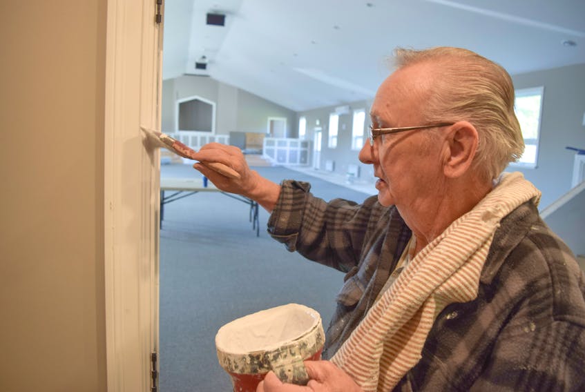 Ellery Cameron puts some final touches of paint on trim at Bethel Baptist Church in Westville. Volunteers have helped build a new 4,800-square-foot addition.