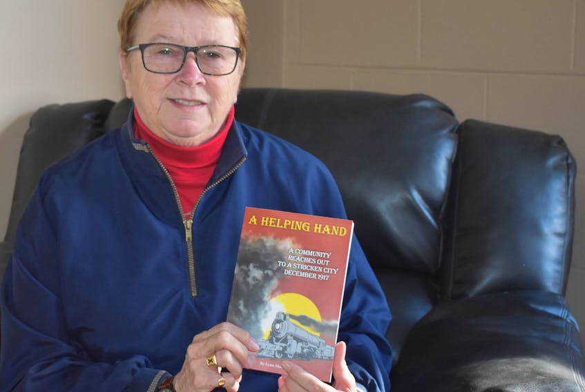 Lynn MacLean holds a copy of her book, A Helping Hand, a historical fiction book for youth which tells of the Halifax Explosion and New Glasgow’s response.