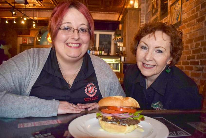 The Kinette Club of New Glasgow is planning a Burger Bonanza for next month. Megan Hartling, left, a member of the Kinnettes, is shown with Darlene Muir of Andre’s Seats in Stellarton, with an Andre’s Burger. KEVIN ADSHADE/THE NEWS