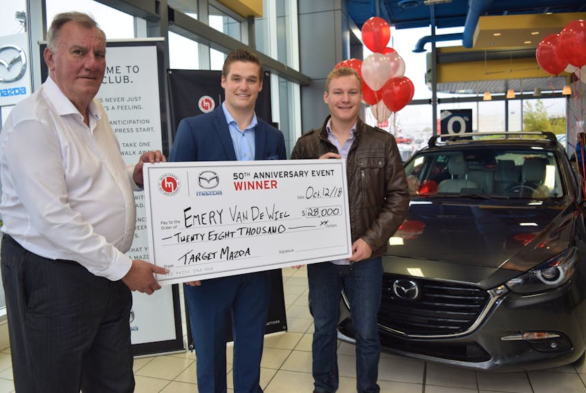 Bob Thompson, left, a salesman at Target Mazda in New Glasgow, is shown with dealership owner Ben Smith and Emery van de Weil, whose recently-purchased car is being paid for by Mazda Canada.