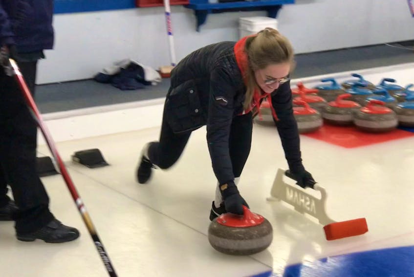 French exchange student Elsa Lopes-Quintas tries her hand at curling at the New Caledonia Curling Club in Pictou on Saturday.