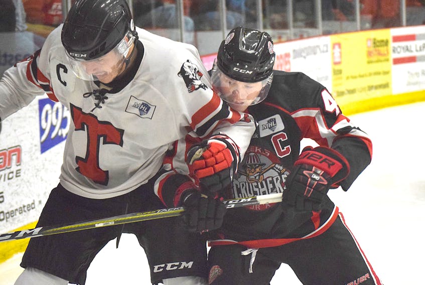 Campbell Pickard, left of the Truro Bearcats and Michael Dill of the Pictou County Weeks Crushers duel for the puck along the boards Friday night in Truro during MHL play. Dill scored a goal and Pickard had the only marker for Truro as the Crushers took a 4-1 victory.