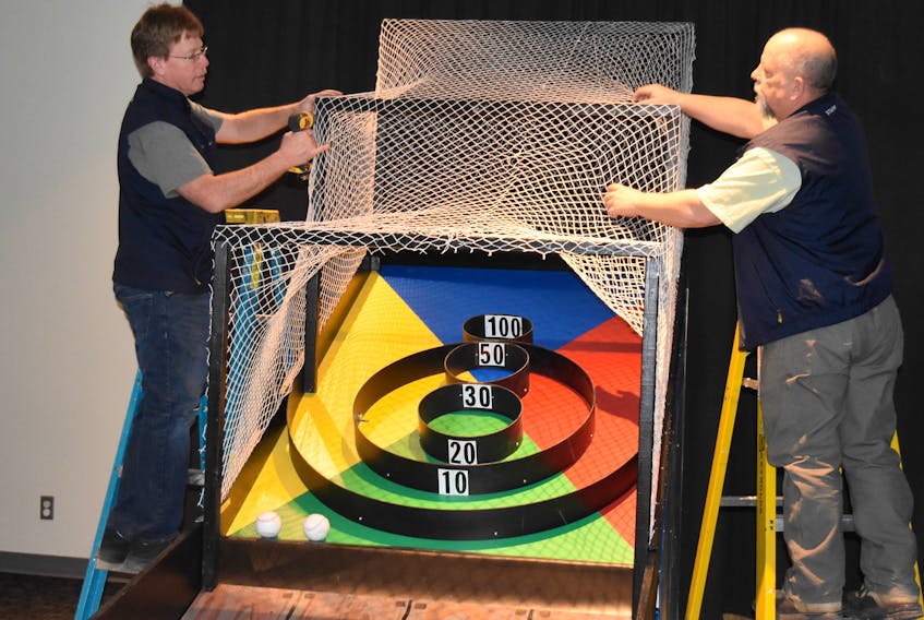 Museum of Industry employees Scott Ross and Jamie Livingstone put some finishing touches on a midway game that will be set up as part of the March break activities between March 16 and March 24.