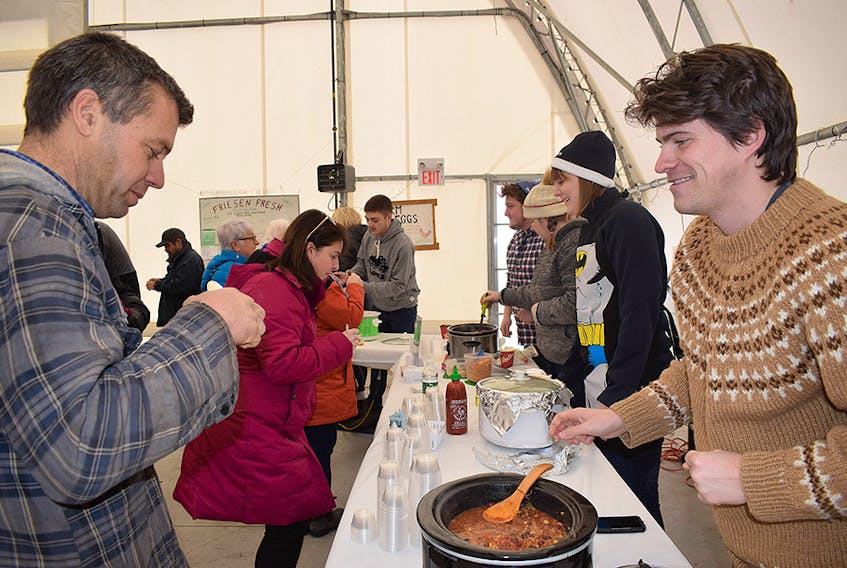 Brendan Ahern, a reporter with The News, hands out a chili sample on Saturday.