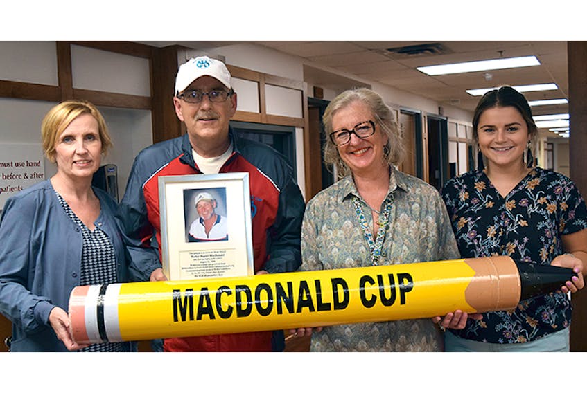 The Walter MacDonald Charity Golf Tournament Fore Palliative Care will take place July 21, with money raised going toward the Palliative Care Unit at Aberdeen Hospital. From left are: palliative consult nurse Rhonda Langille, organizer Mike MacNaughton (helping to holding the big pencil, a wink and a nod to those who might need an eraser to “fix” their scorecard), director of palliative care Dr. Anne Kwasnik, and Kelsey MacDonald, a music therapist at the unit.