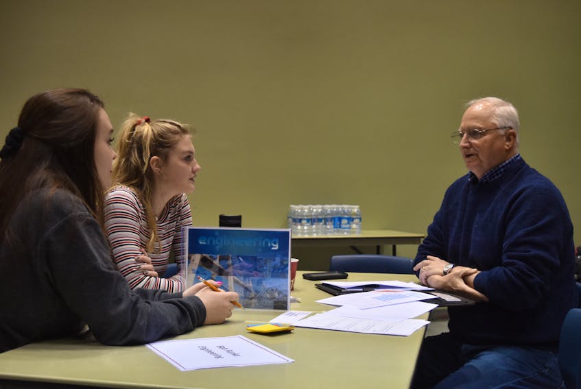 Kassidi Wong and Miah Burrows speak with Bob Funke at the engineering table during Mentoring Plus