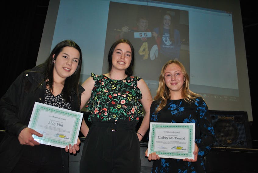 Abby Vint, left, and Lindsey MacDonald, right, are shown with Jenna Hickey after being presented with the GG Award at the Subway Selects year-end banquet this week. The GG Award is named in memory of Hickey’s great grandmother Margaret, who is shown in a photo in the background.