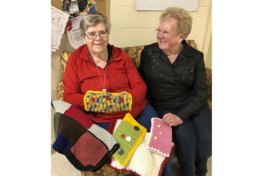 Helen Cruickshank from the Pictou District Women’s Institute (right) and Valley View Villa resident Kay Duggins show off some knitted items donated by the Institute.