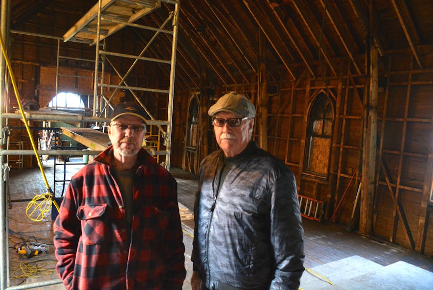 St. Matthew's Presbyterian Church board members Bob Thompson, left, and Lucien Forbes stand in the sanctuary of the church. Work is being done to restore the space after a fire in late October.