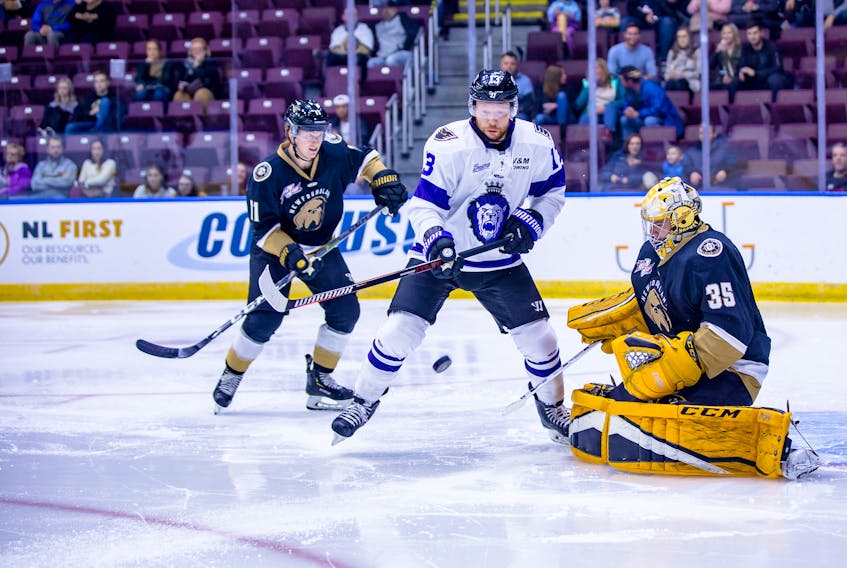 Newfoundland Growlers goaltender Patrick Munson makes one of his 39 saves as Growlers defencemen Mac Hollowell (11) and Reading Royals forward Olivier Labelle (13) look on during their ECHL game at Mile One Centre in St. John's Saturday night. Hollowell would later score the game-winner in overtime as the Growlers prevailed 3-2. — Newfoundland Growlers photo/Jeff Parsons
